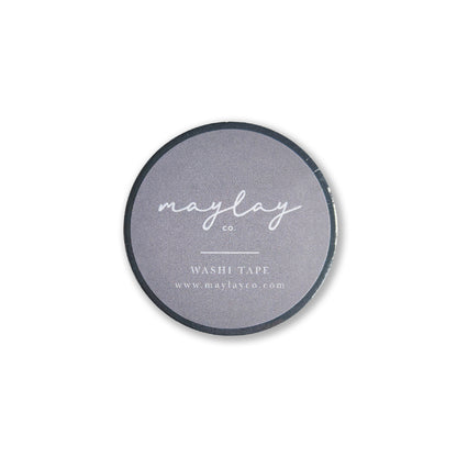 A circular roll of decorative washi tape featuring a dark gray label with the text "Maylay Co., I AM GRATEFUL WASHI TAPE - SLATE BLUE, and www.maylayco.com"—ideal for journaling or scrapbooking enthusiasts.